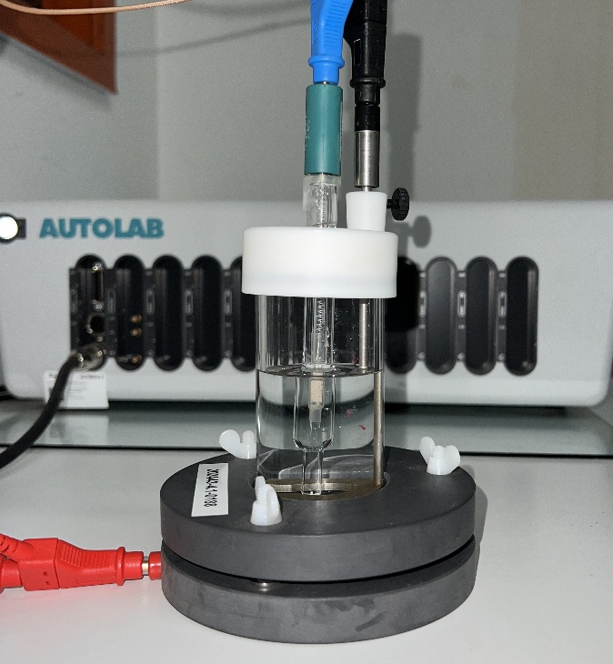 Three-electrode electrochemical test cell and potentiostat
